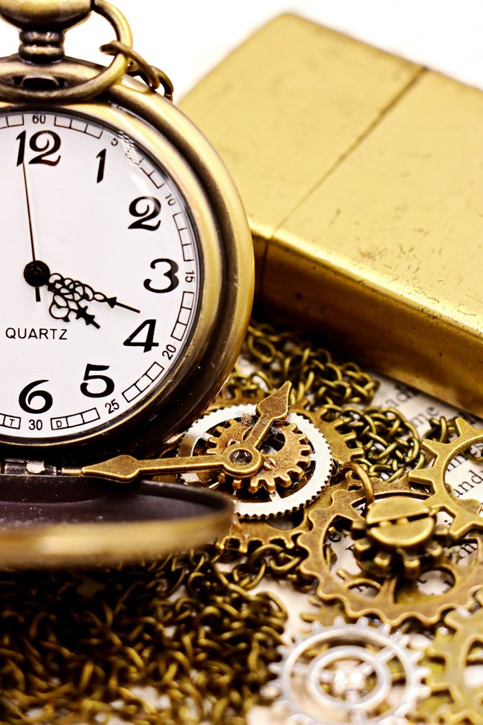 Elegant vintage pocket watch with gold chain and accessories, illustrating time's passage.